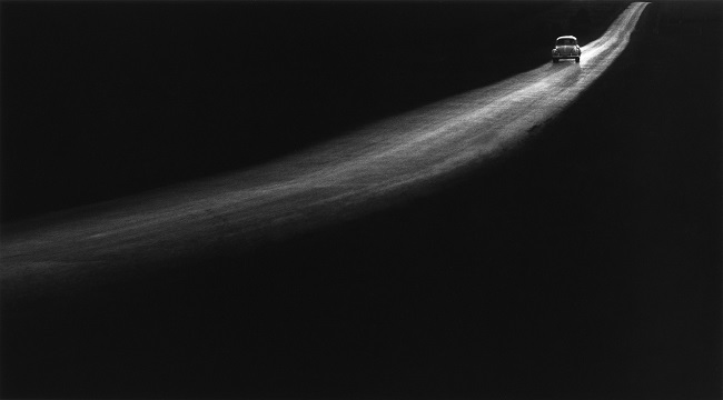 Photographie d'une voiture dans la nuit par George TICE. L'image est en noir et blanc et a été réalisé dans les années 1960.